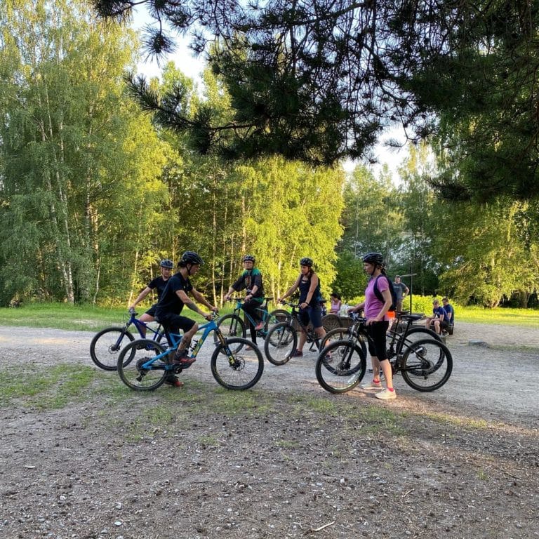 grupp cyklister står tillsammans på en grusväg