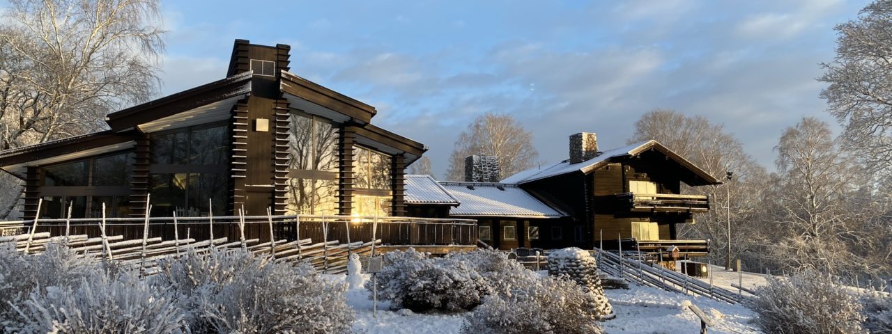 Brunt hus med snö och blå himmel