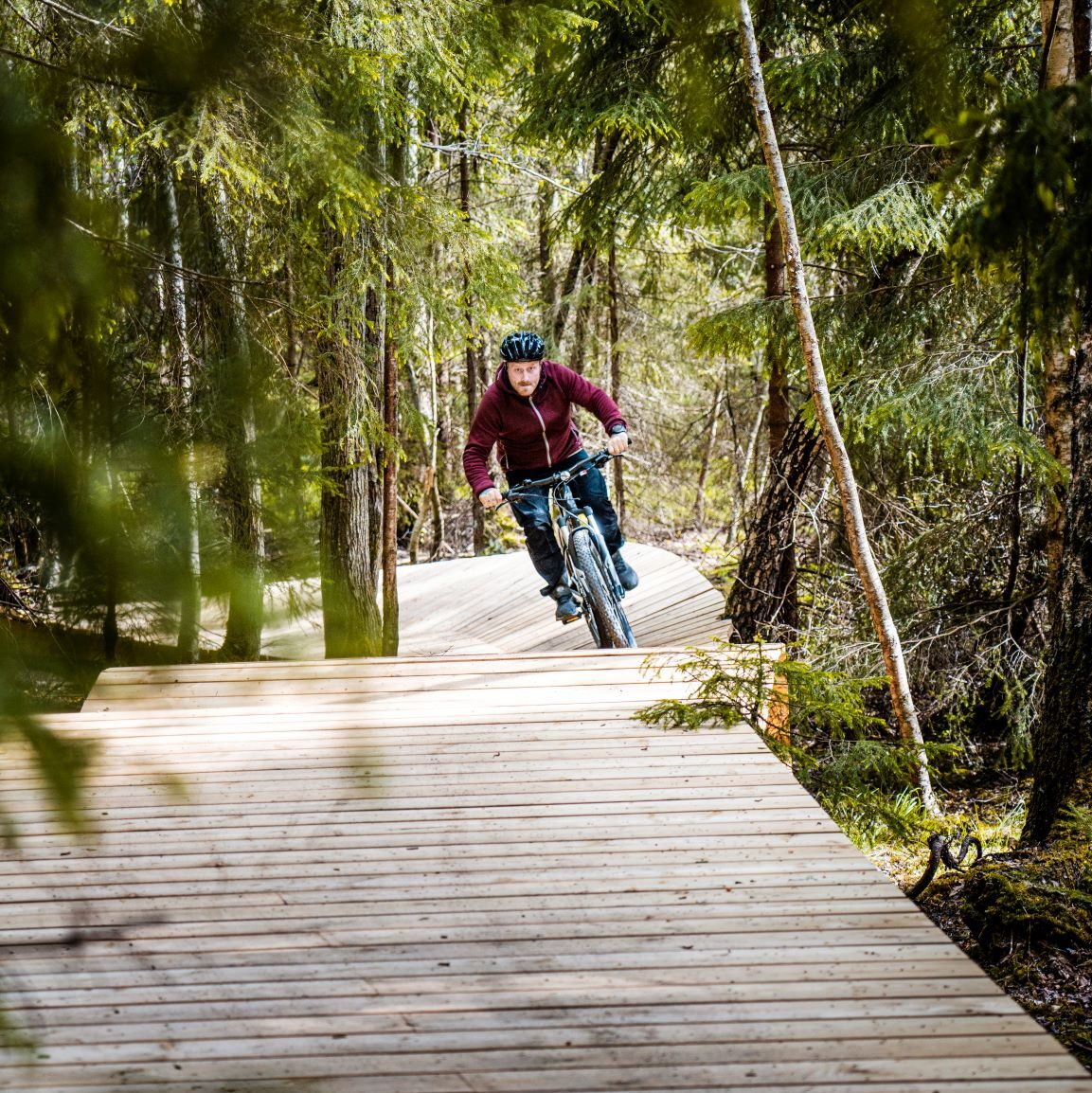 mountainbikecyklist på träbro i skogen