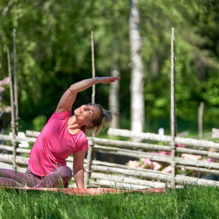 kvinna gör yoga i gräset