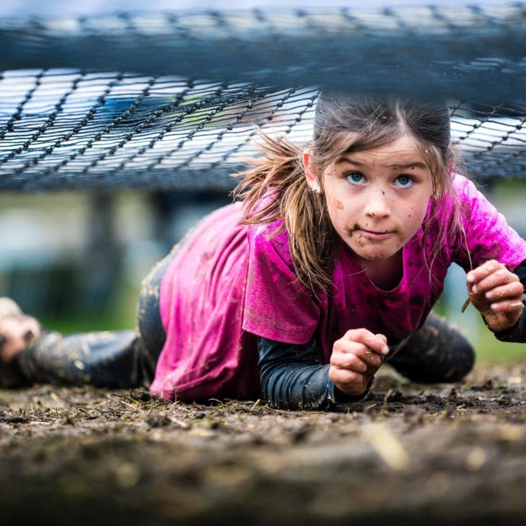 barn kryper på marken i ett hinderbanelopp