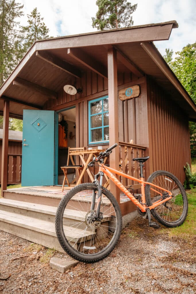 En cykel som står parkerad utanför en trästuga.
