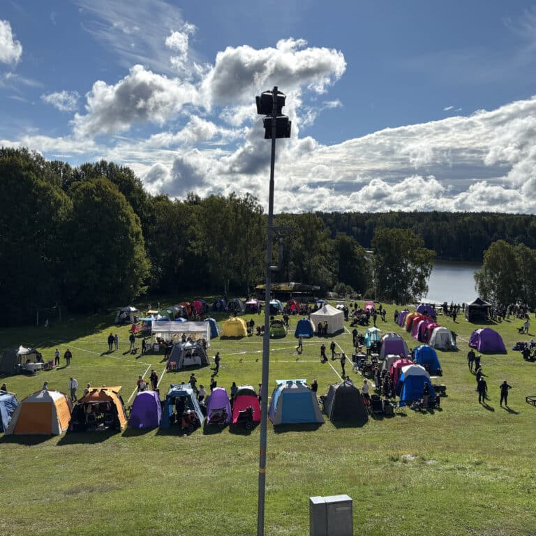 En stor grupp tält uppställda på en äng.