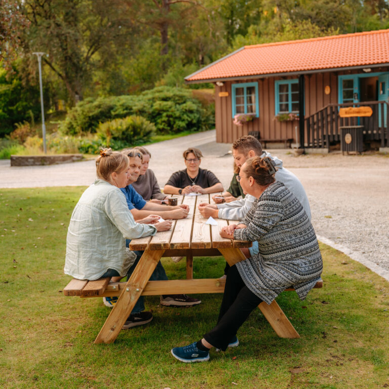 En grupp människor som sitter vid ett picknickbord.